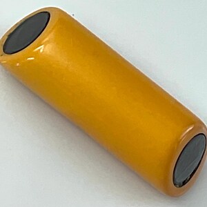 May include: A cylindrical lithium-ion battery with a smooth, solid yellow casing. The battery features flat, circular black contact points at both the top and bottom ends, providing a clean and simple design for this rechargeable power cell unit.