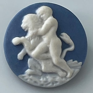 May include: A blue and white oval cameo featuring a classical relief sculpture. The sculpture depicts a figure riding a lion. The background is a solid, deep blue, and the figures are rendered in white, creating a striking contrast.