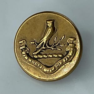 May include: A white ceramic mug with a black handle and the text "But First, Coffee" in a bold, black font. The mug is set against a neutral background, highlighting its simple design.