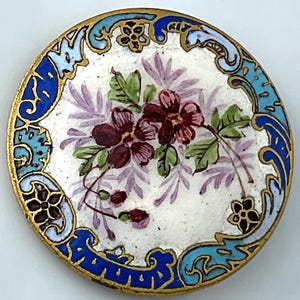 May include: A round button featuring a white enamel center with a painted floral design in shades of dark red, green, and light purple. The border is decorated with gold metal filigree and vibrant blue and light blue enamel accents.