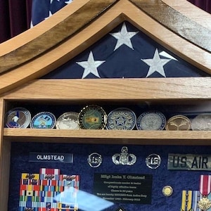 May include: A wooden display case with a flag design and the words "US AIR FORCE". The case contains medals, ribbons, and coins. The top of the case has a wooden frame with a flag design and white stars.