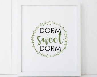 May include: White framed print with a green leafy wreath around the text "Dorm Sweet Dorm".