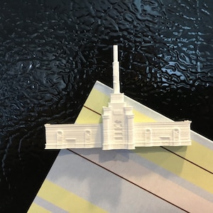 Peut inclure: Modèle miniature blanc d'un bâtiment d'église avec un haut clocher. Le modèle est en plastique et présente un design détaillé.