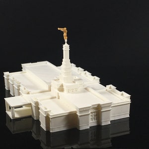 Peut inclure: Modèle 3D imprimé en blanc d'un temple avec une statue dorée au sommet. Le modèle est détaillé et comprend une petite entrée sur le côté.
