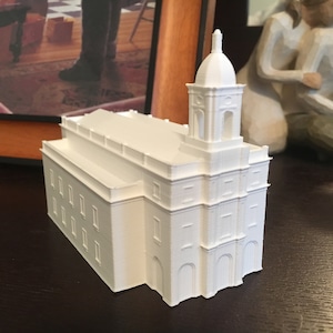 Puede incluir: Un modelo de iglesia blanco impreso en 3D con una torre alta y un techo abovedado.