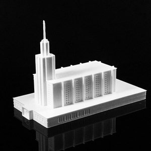 Może przedstawiać: Biały model kościoła wydrukowany w 3D z wysoką wieżą.