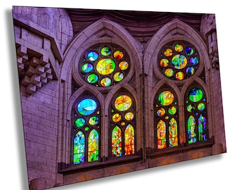 May include: A close-up of a stained glass window in a church. The window is made up of many small, colorful pieces of glass, arranged in a geometric pattern. The colors of the glass are vibrant and include red, orange, yellow, green, blue, and purple.