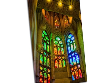 May include: A close-up view of a stained glass window in a church. The window is made up of many small pieces of glass, each with a different color. The colors of the glass create a beautiful rainbow effect. The window is set in a stone frame.