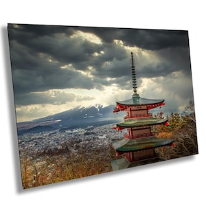 May include: A red and green pagoda with a mountain range in the background. The pagoda is surrounded by trees and a city in the distance. The sky is cloudy with a ray of sunlight shining through the clouds.