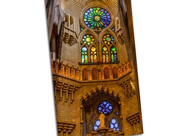 May include: A stained glass window in a cathedral with a large circular window in the center and smaller rectangular windows on either side. The windows are made of colorful glass and depict religious scenes.