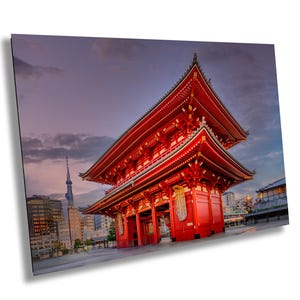 Op de afbeelding: Een rode, meerlaagse pagode met een gouden dak en ingewikkelde details staat tegen een bewolkte lucht. De pagode is een traditionele Japanse bouwstijl.