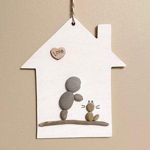 Décoration artistique en galets représentant un personnage et un chat : décoration en bois flotté fait main