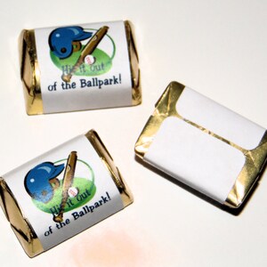 May include: Three small chocolate bars wrapped in gold foil with white labels. The labels have a baseball theme and say "Hit it out of the ballpark!"