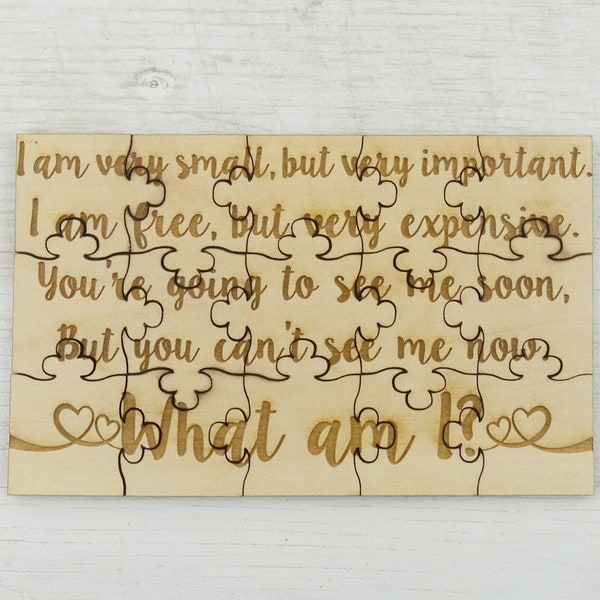 May include: A wooden jigsaw puzzle with the text "I am very small, but very important. I am free, but very expensive. You're going to see me soon, But you can't see me now. What am I?" 