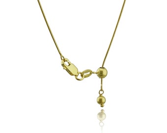May include: A gold chain necklace with a sliding clasp and a small gold bead at the end.