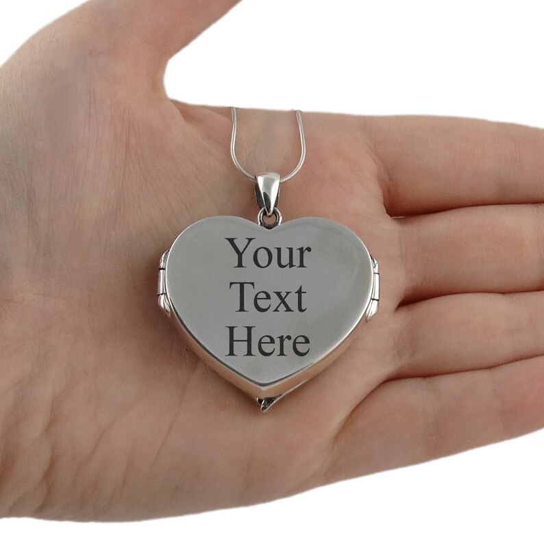 May include: Silver heart-shaped locket necklace with a hinged opening. The locket is engraved with the text "Your Text Here".