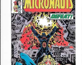 May include: A vintage comic book cover for "The Micronauts" featuring a dynamic illustration. The cover displays a black figure with arms raised, a defeated figure, and the word "DEFEAT!". The Marvel Comics Group logo is at the top.