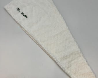 May include: White terry cloth hair towel with the text "Mrs. Dubble" embroidered in green.