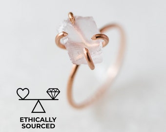 May include: A delicate gold ring with a clear, faceted crystal stone. The ring is ethically sourced.