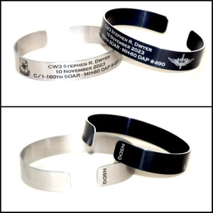 May include: Two metal bracelets, one silver and one black, with engraved text. The silver bracelet reads "CW3 STEPHEN R. DWYER 10 NOVEMBER 2023 C/1-160TH SOAR-MH-60 DAP #490". The black bracelet reads "CW3 STEPHEN R. DWYER 10 NOVEMBER 2023 1-160TH SOAR-MH-60 DAP #490" and has a small winged insignia.