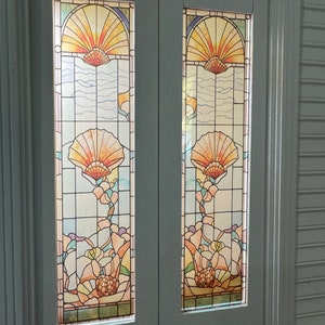Puede incluir: Un par de puertas dobles blancas con paneles de vidrio emplomado que presentan un diseño de concha y flores en tonos de amarillo, naranja, rosa y azul.