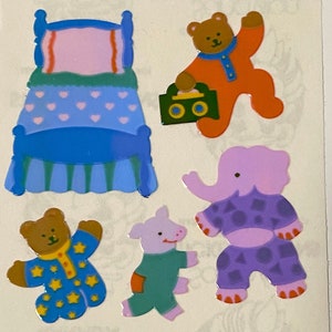 Pode incluir: Um conjunto de cinco adesivos coloridos com um leito, um porco, um elefante e dois ursos vestindo pijamas. Os adesivos são perfeitos para adicionar um toque de fantasia a qualquer projeto.