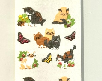 Könnte beinhalten: Ein Bogen Aufkleber mit Illustrationen von Katzen in Braun, Orange und Schwarz, sowie Schmetterlingen. Die Katzen sind in verschiedenen Posen dargestellt, einige mit Blumen. Die Schmetterlinge sind in Rot- und Gelbtönen gehalten.
