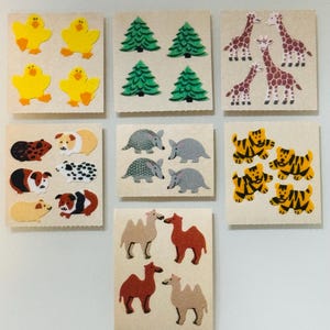 May include: A sheet of stickers featuring various animals, including armadillos, guinea pigs, camels, tigers, and birds. The stickers are on a white background.
