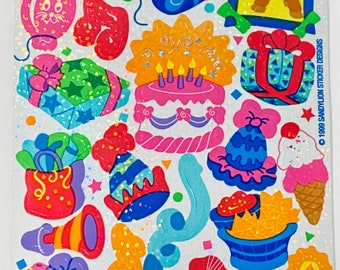 May include: A sheet of colorful birthday party stickers with a variety of images including a cake, presents, balloons, a donkey, a hot dog, ice cream, and party hats. The stickers are on a white background with a glittery finish. © 1989 Sandylion Sticker Designs.