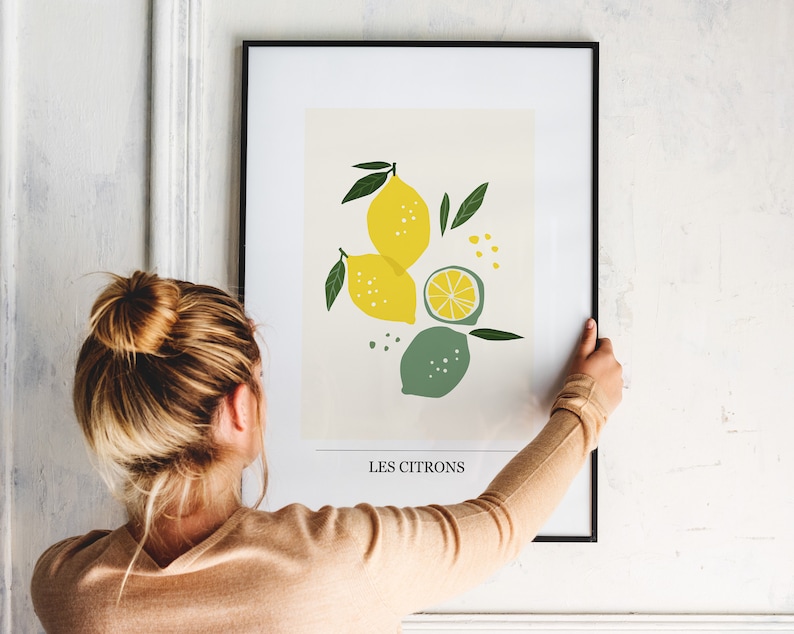 May include: A framed print with a stylized illustration of lemons and limes. The print has the text "Les Citrons" at the bottom.