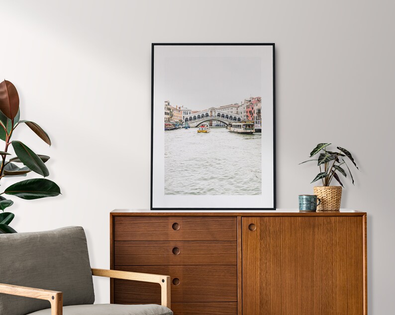 Puede incluir: Una fotograf&iacute;a enmarcada en negro de un puente sobre un canal en Venecia, Italia. El puente es de piedra y tiene varios arcos. Hay barcos en el canal y edificios a ambos lados del canal.