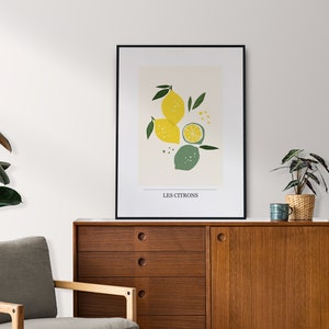 May include: A black framed print with a minimalist illustration of lemons and limes on a cream background. The text "LES CITRONS" is printed at the bottom of the print.