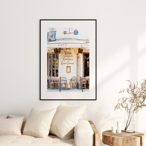 May include: A black and white photo of a Parisian cafe with a sign that reads "Vins en Propriete, Cocktails, Cuisine Savoureuse" and a cafe sign that reads "Cafe".