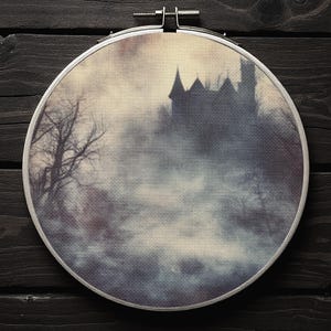 Könnte beinhalten: Ein Kreuzstich-Stickrahmen mit einer gruseligen Schloss-Szene. Das Kunstwerk zeigt ein silhouettenhaftes Schloss mit hohen Türmen, kahlen Bäumen und einem nebligen Hintergrund. Die Farbpalette umfasst Grautöne, Blau und Beige.