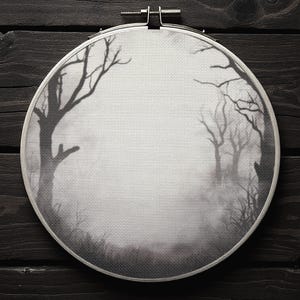 Pode incluir: Um bastidor de bordado a preto e branco com uma cena de floresta enevoada com &aacute;rvores despidas. A obra de arte &eacute; definida contra um fundo cinzento, criando um efeito atmosf&eacute;rico. O bastidor &eacute; de metal e est&aacute; montado numa superf&iacute;cie de madeira escura.