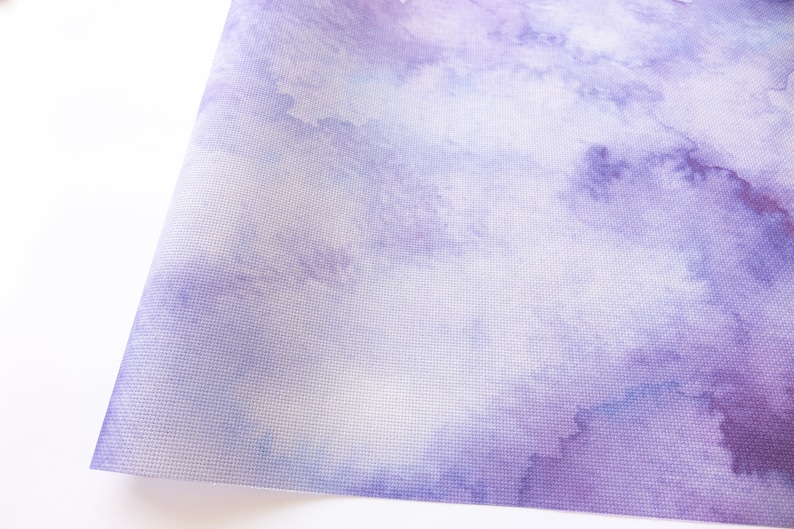 Pode incluir: Um close-up de um tecido roxo claro com um padr&atilde;o sutil de aquarela. O tecido tem uma superf&iacute;cie texturizada e uma apar&ecirc;ncia suave e desbotada.