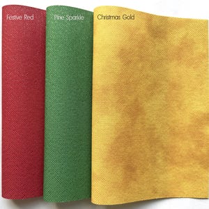May include: Three fabric swatches in festive colors. The first is a deep red labeled "Festive Red." The second is green with sparkle, labeled "Pine Sparkle." The third is gold, labeled "Christmas Gold."