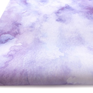 Pode incluir: Um tapete de ioga de aquarela roxo e branco com uma superf&iacute;cie macia e texturizada.