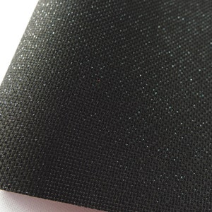 Könnte beinhalten: Schwarzer Stoff mit einem dezenten Glitzern. Der Stoff hat eine gewebte Textur.