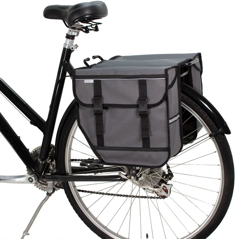 Peut inclure: Un sac de v&eacute;lo gris avec des sangles et des boucles noires, fix&eacute; au porte-bagages arri&egrave;re d'un v&eacute;lo noir.