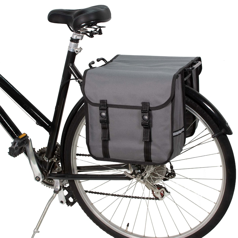 May include: A black bicycle with a grey and black pannier bag attached to the rear rack. The pannier bag has two large compartments and two adjustable straps.