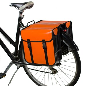May include: A black bicycle with an orange and black pannier bag attached to the rear rack. The bag has two buckles on the front.
