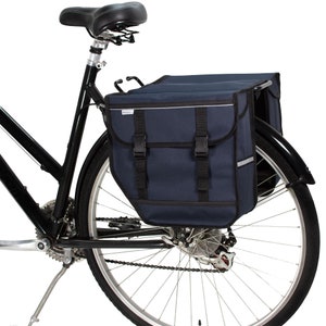 Peut inclure: Un v&eacute;lo noir avec un sac de porte-bagages arri&egrave;re bleu fonc&eacute;. Le sac a deux compartiments et est s&eacute;curis&eacute; par des boucles.