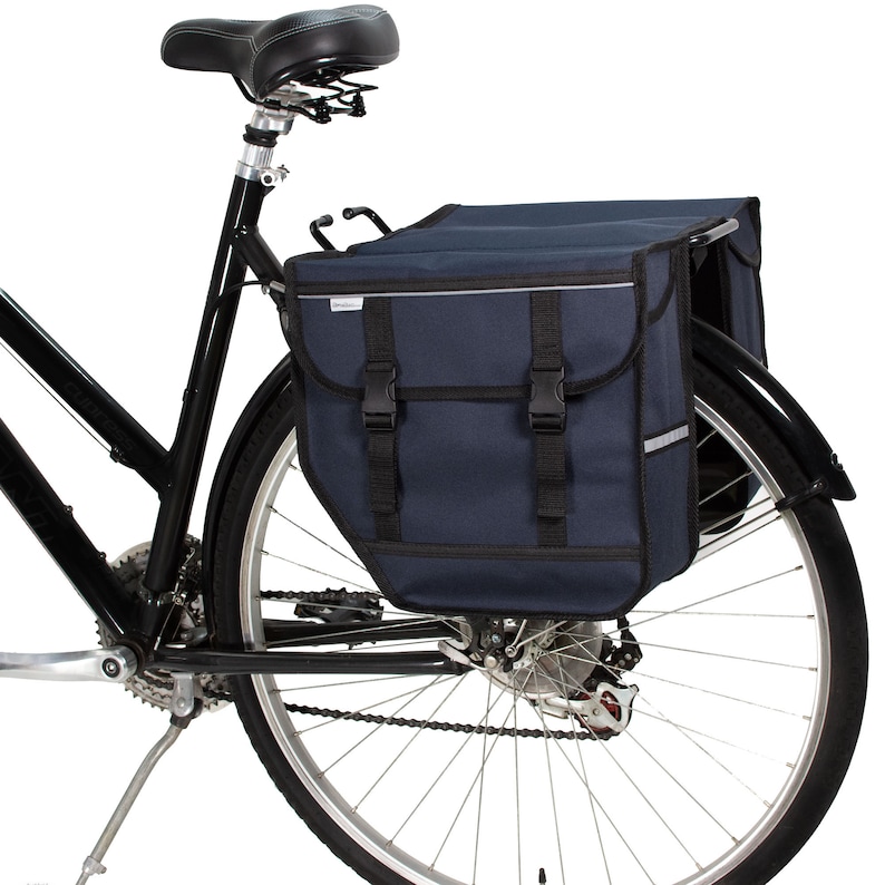 Peut inclure: Un v&eacute;lo noir avec un sac de porte-bagages arri&egrave;re bleu fonc&eacute;. Le sac a deux compartiments et est s&eacute;curis&eacute; par des boucles.
