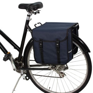 May include: A black bicycle with a dark blue rear rack and two panniers. The panniers have black straps and buckles.