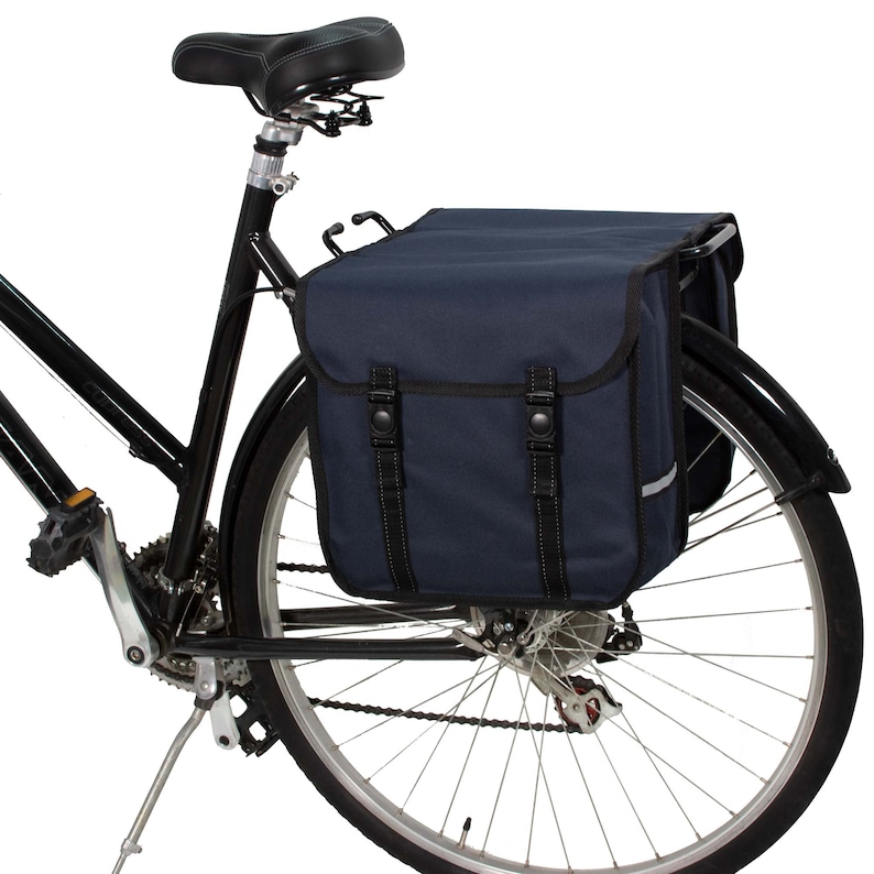 May include: A black bicycle with a dark blue rear rack and two panniers. The panniers have black straps and buckles.