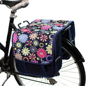 Pu&ograve; includere: Un paio di borse da bicicletta blu con stampa floreale. Le borse sono attaccate a una bicicletta nera.