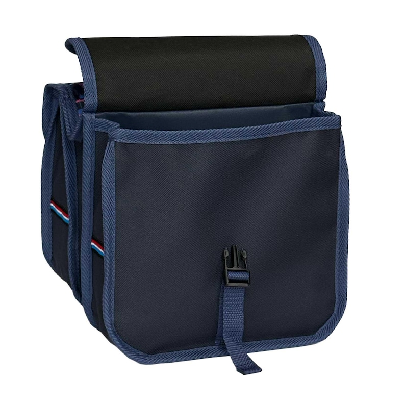 May include: A navy blue bicycle pannier bag featuring a black top flap, blue fabric trim, and a central plastic buckle closure. The side panel displays a thin horizontal stripe in red, white, and blue, with a structured design and durable fabric.