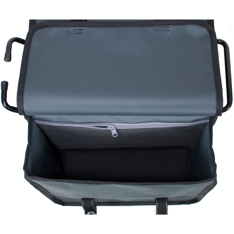 May include: A black and grey bike rack bag with a zipped pocket and two straps. The bag is open and the inside is visible.