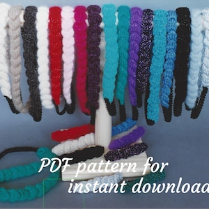 Pode incluir: Uma exibição de faixas de cabeça de crochê em várias cores, incluindo bege, preto, branco, vermelho, rosa, roxo, azul-turquesa, azul e preto. As faixas de cabeça estão dispostas em um suporte de madeira. O texto "PDF pattern for instant download" é visível na imagem.